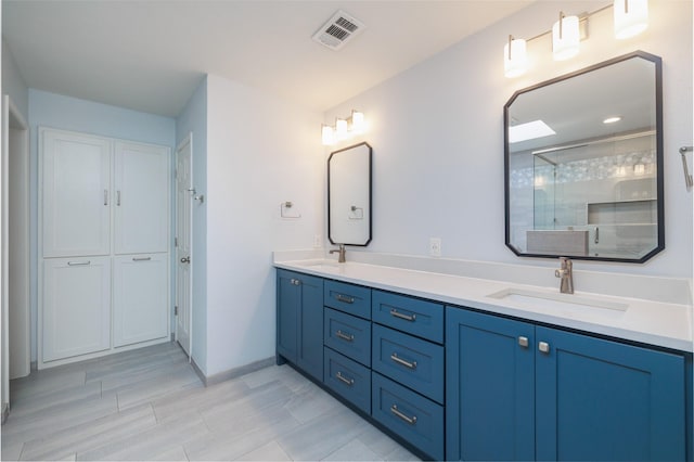 bathroom with a shower with door and vanity