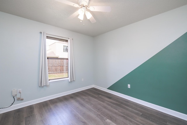 empty room with ceiling fan, dark hardwood / wood-style floors, and a textured ceiling