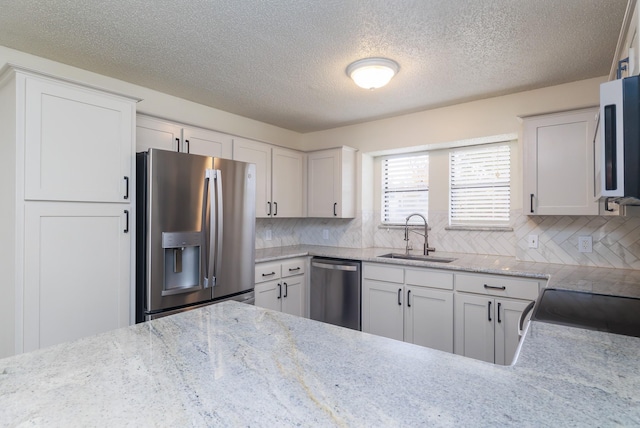 kitchen with white cabinetry, sink, tasteful backsplash, and appliances with stainless steel finishes