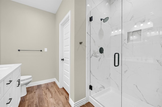 bathroom with vanity, hardwood / wood-style floors, toilet, and walk in shower