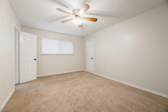 unfurnished room with ceiling fan and light carpet