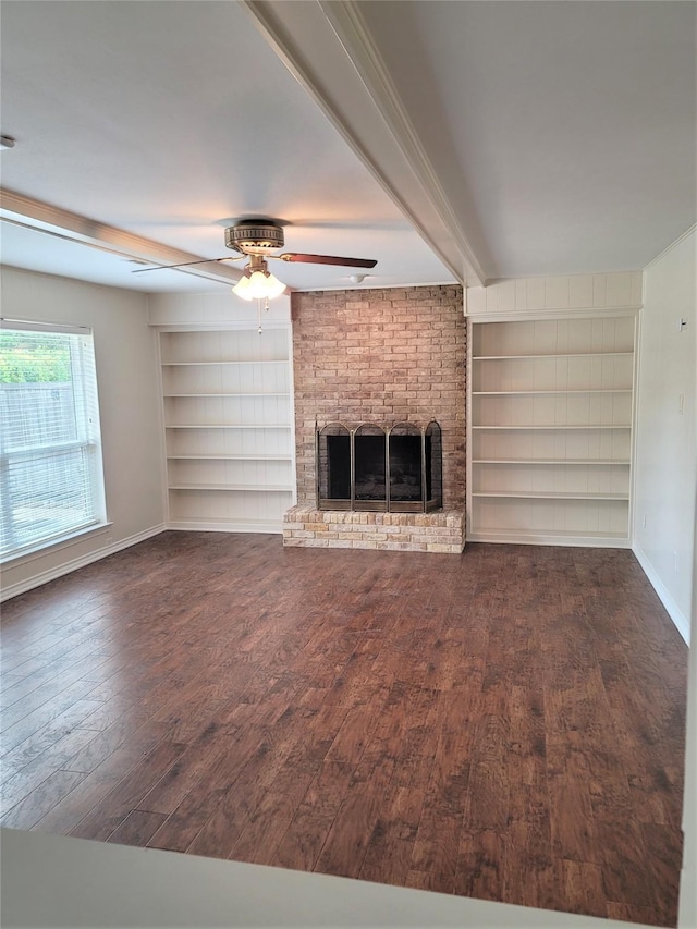 unfurnished living room featuring built in shelves, dark hardwood / wood-style flooring, beamed ceiling, ceiling fan, and a fireplace