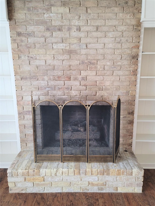 details featuring wood-type flooring and a brick fireplace