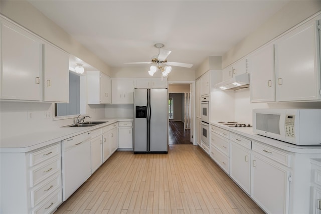 kitchen with white appliances, white cabinets, sink, ceiling fan, and light hardwood / wood-style floors