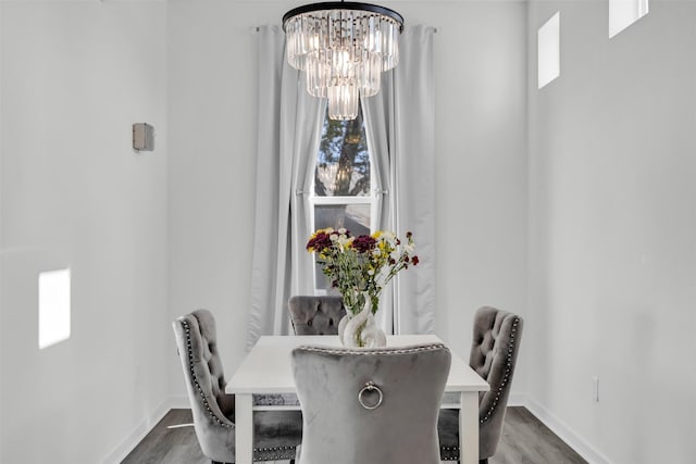 dining space featuring dark wood-type flooring and a chandelier