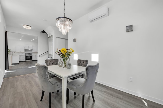 dining room with dark hardwood / wood-style flooring, a notable chandelier, sink, and a wall mounted AC