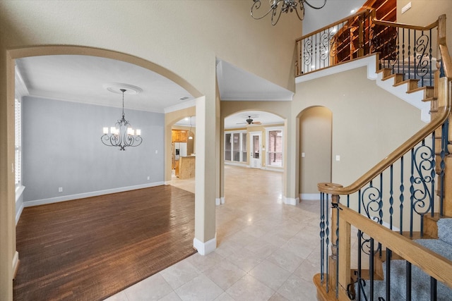 entrance foyer with crown molding, wood-type flooring, and ceiling fan with notable chandelier