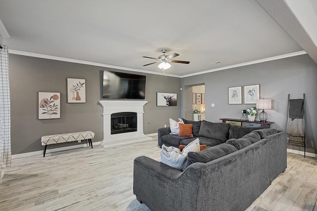 living room featuring crown molding, light hardwood / wood-style flooring, and ceiling fan