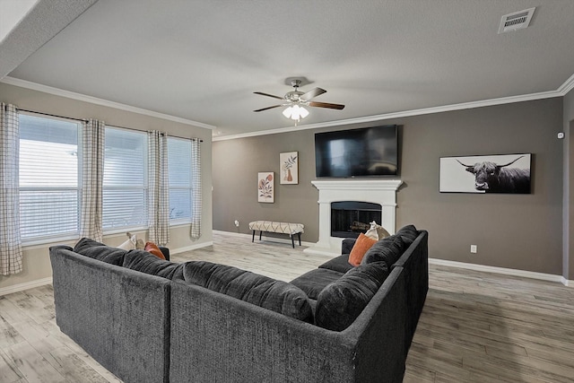 living room with hardwood / wood-style flooring, ceiling fan, and crown molding