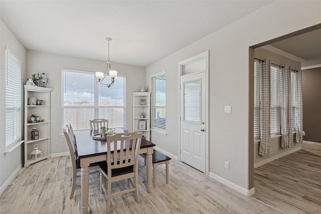 dining space featuring plenty of natural light, an inviting chandelier, and light wood-type flooring