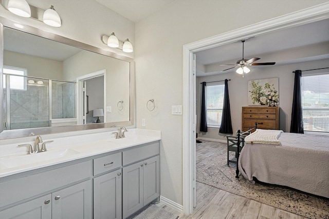 bathroom with hardwood / wood-style floors, ceiling fan, a shower with shower door, and vanity