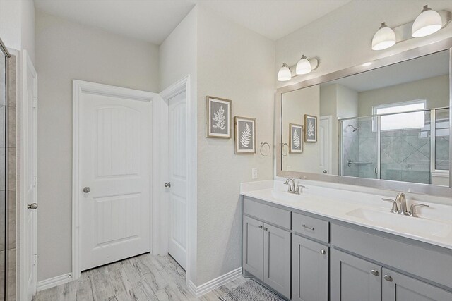 bathroom featuring a shower with door, vanity, and wood-type flooring