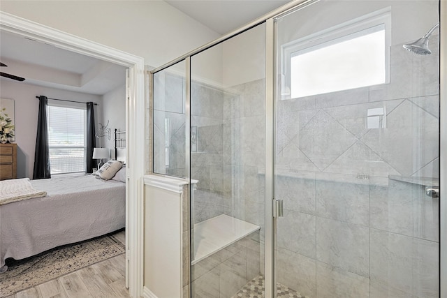 bathroom featuring ceiling fan, wood-type flooring, and a shower with door