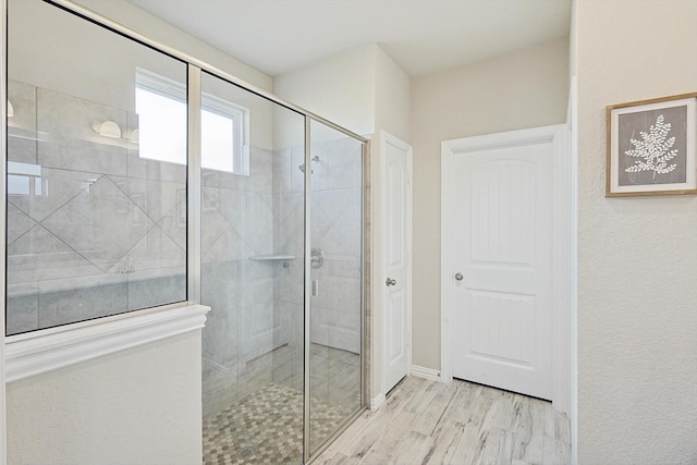 bathroom with hardwood / wood-style flooring and an enclosed shower