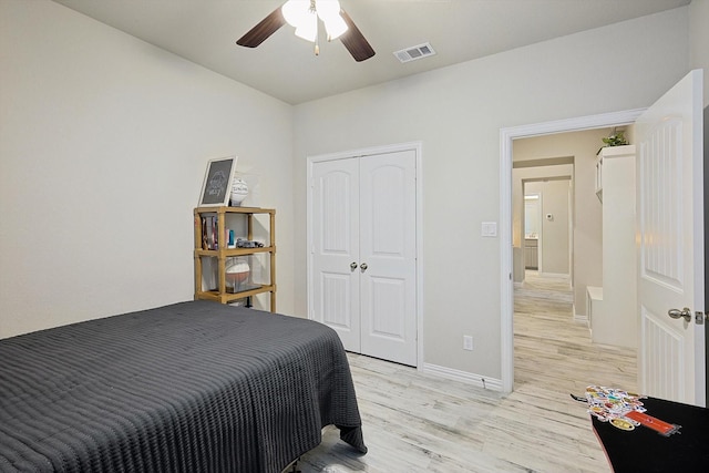 bedroom with ceiling fan, light hardwood / wood-style floors, and a closet