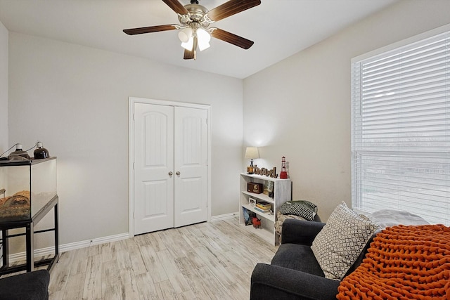 sitting room with ceiling fan and light wood-type flooring