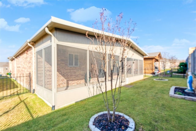 rear view of property with a sunroom and a yard