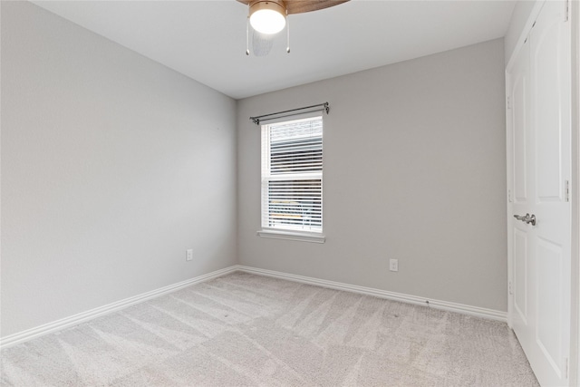 spare room featuring light carpet and ceiling fan