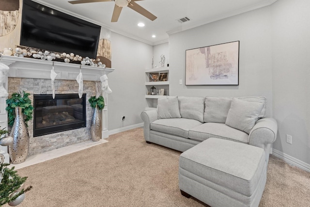 carpeted living room with a fireplace, ceiling fan, and crown molding