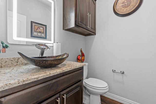 bathroom with vanity, toilet, and wood-type flooring