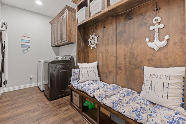 laundry area featuring cabinets, dark hardwood / wood-style flooring, and washing machine and dryer