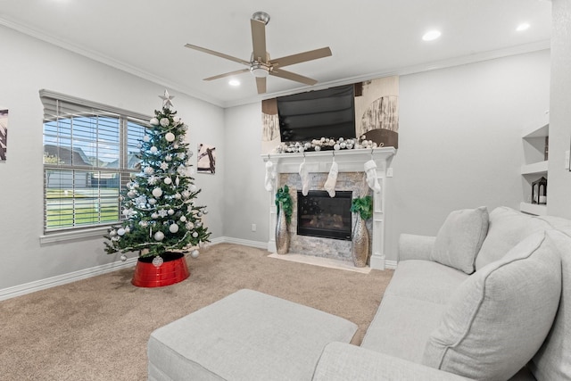 living room with ceiling fan, a fireplace, carpet, and ornamental molding