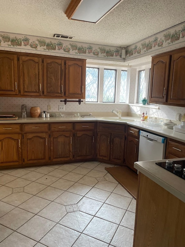 kitchen with dishwasher, a textured ceiling, and sink