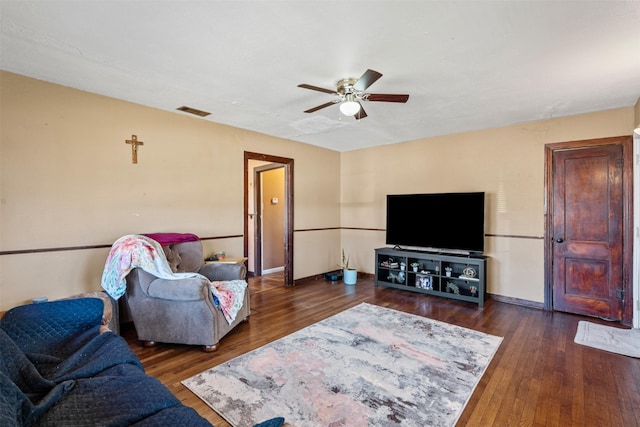 living room with dark wood-type flooring and ceiling fan