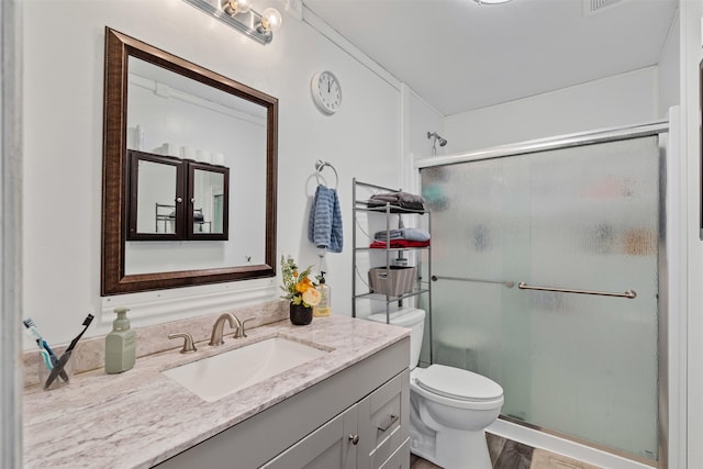 bathroom with vanity, hardwood / wood-style floors, an enclosed shower, and toilet