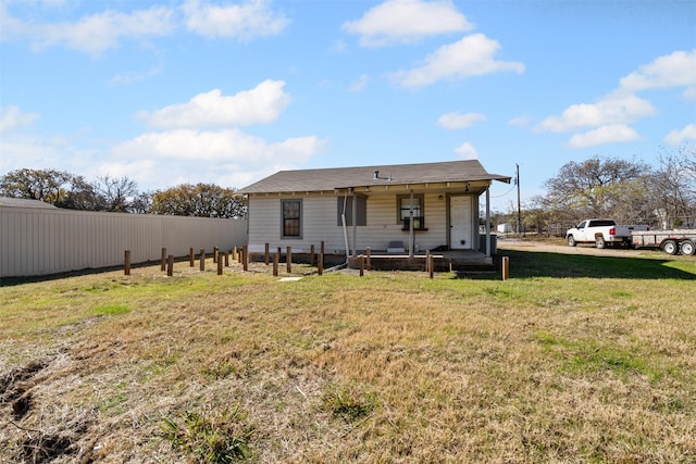 rear view of house featuring a porch and a lawn