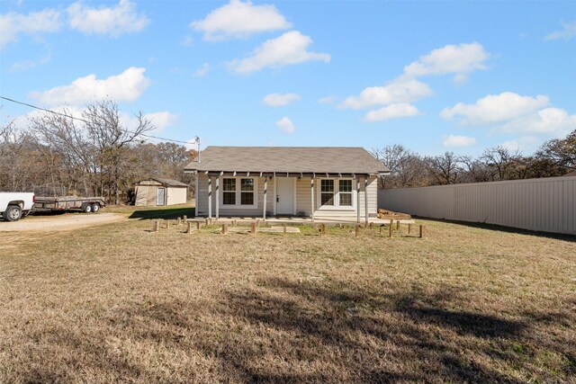 exterior space with covered porch, a storage unit, and a front lawn