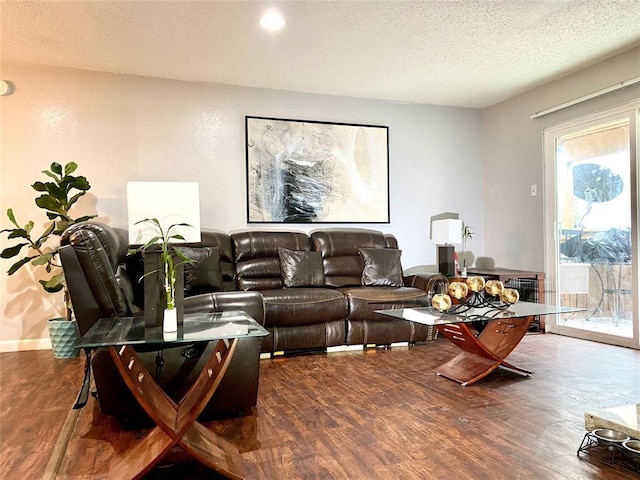 living room featuring a textured ceiling and dark wood-type flooring