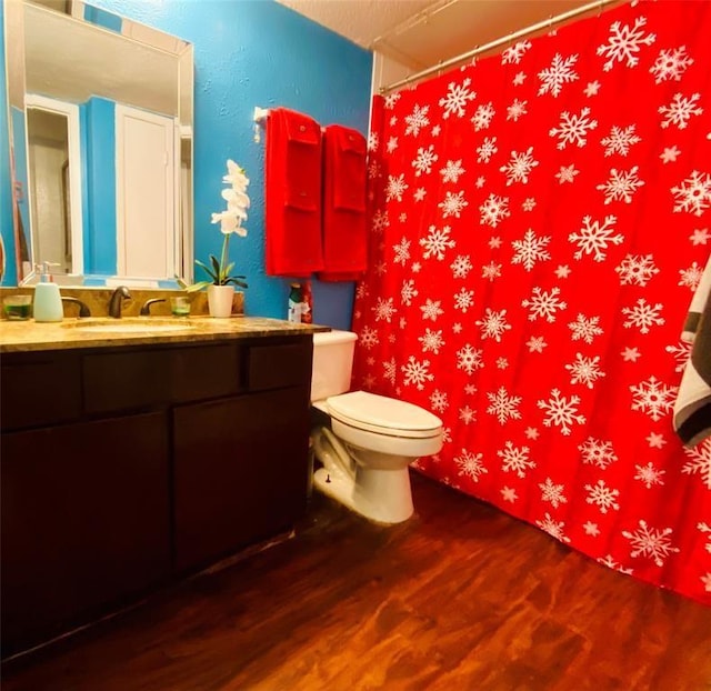 bathroom with toilet, vanity, and hardwood / wood-style flooring