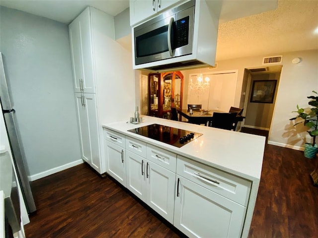 kitchen with dark wood-type flooring, stainless steel appliances, and white cabinets