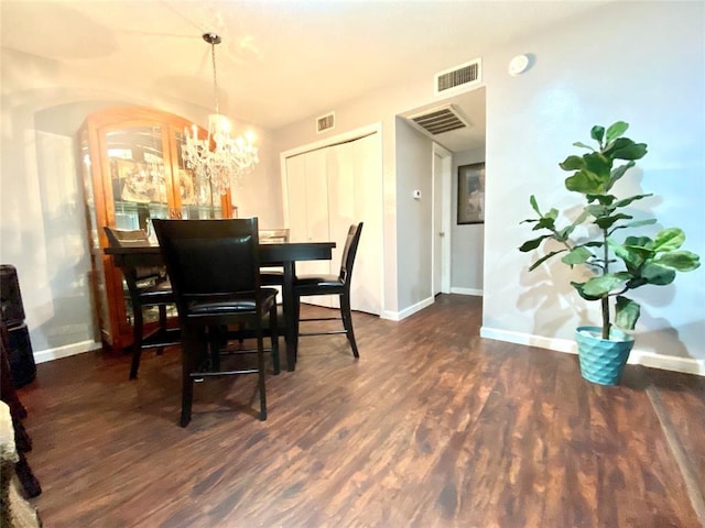 dining area with dark hardwood / wood-style flooring and a notable chandelier