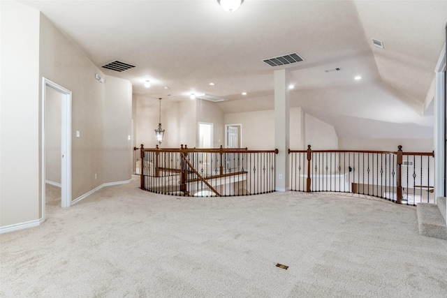 carpeted empty room with vaulted ceiling