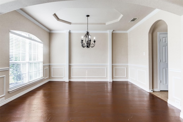 unfurnished dining area with crown molding, dark hardwood / wood-style floors, a raised ceiling, and a chandelier