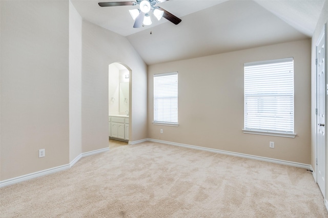 carpeted empty room featuring vaulted ceiling and ceiling fan