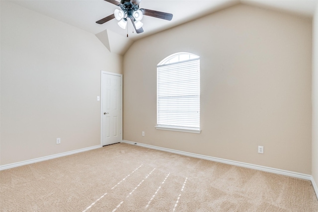 carpeted spare room featuring vaulted ceiling and ceiling fan