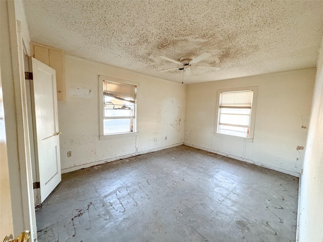 spare room with a textured ceiling and ceiling fan