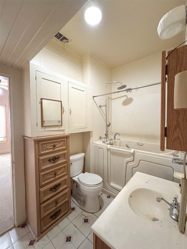 bathroom featuring a washtub, vanity, and toilet