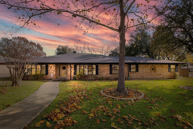 single story home with a lawn