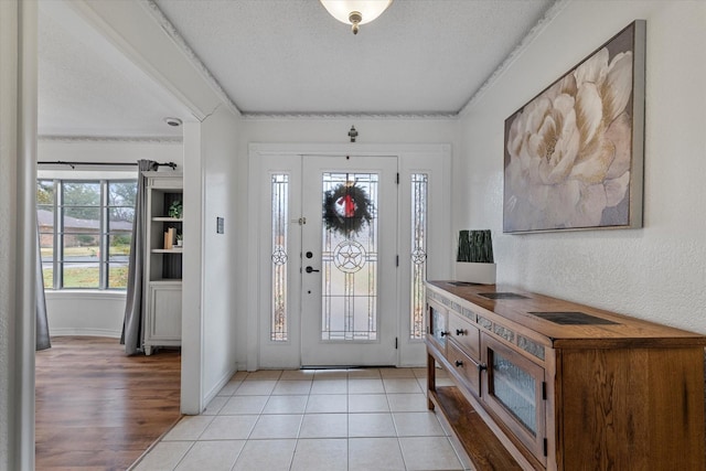 tiled foyer entrance featuring a textured ceiling