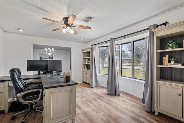 office space featuring ceiling fan with notable chandelier, a textured ceiling, and light hardwood / wood-style flooring