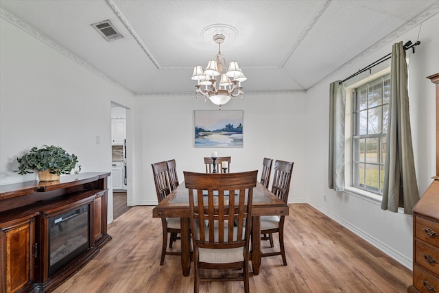 dining area with hardwood / wood-style flooring, a chandelier, and a textured ceiling