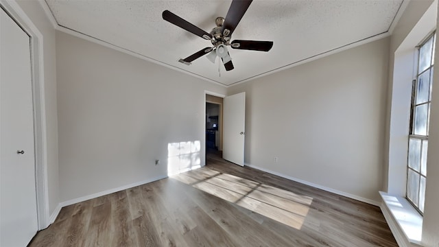 unfurnished room with ceiling fan, light hardwood / wood-style floors, crown molding, and a textured ceiling