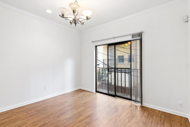 unfurnished room with hardwood / wood-style flooring, a notable chandelier, and crown molding