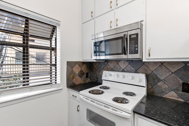 kitchen with backsplash, white cabinets, and white electric range