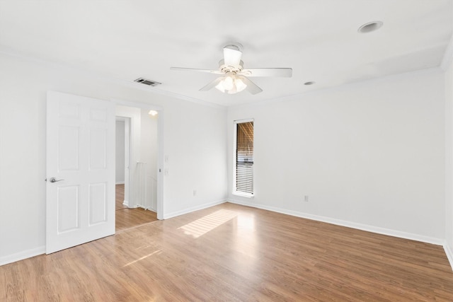 empty room featuring ceiling fan, ornamental molding, and light wood-type flooring