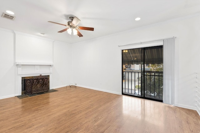 unfurnished living room with ceiling fan, a fireplace, wood-type flooring, and crown molding